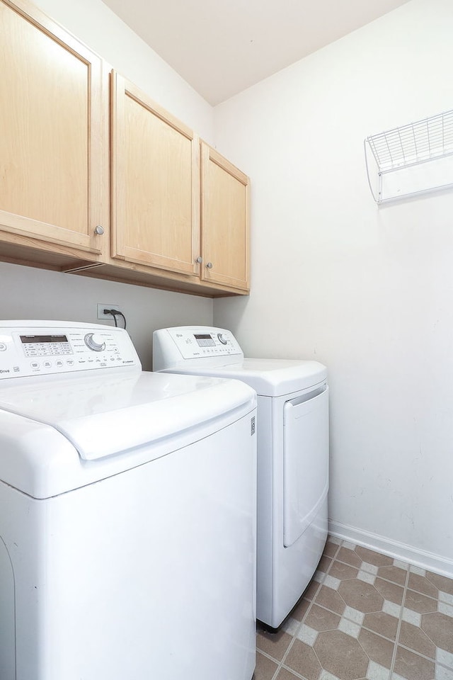 laundry room with baseboards, cabinet space, and washer and dryer