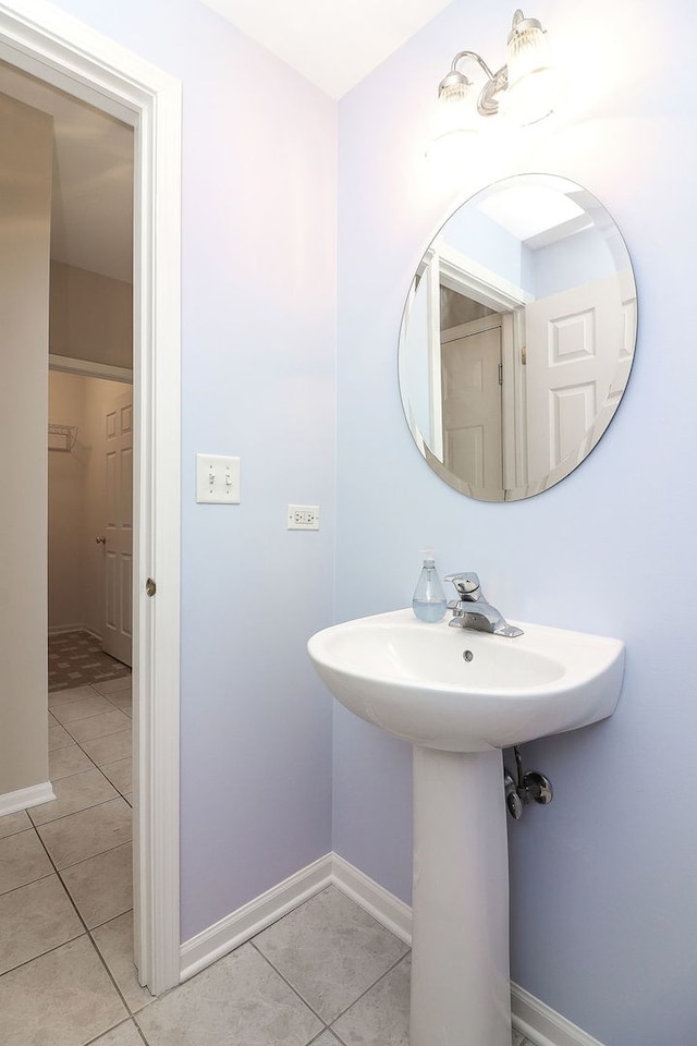 bathroom with baseboards and tile patterned floors