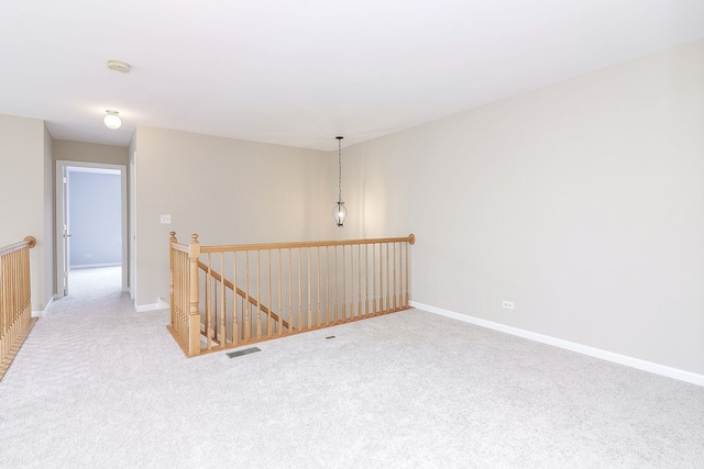carpeted empty room with baseboards and visible vents