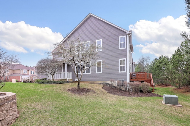 exterior space featuring a front lawn, a wooden deck, and covered porch