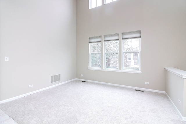carpeted empty room with baseboards and visible vents