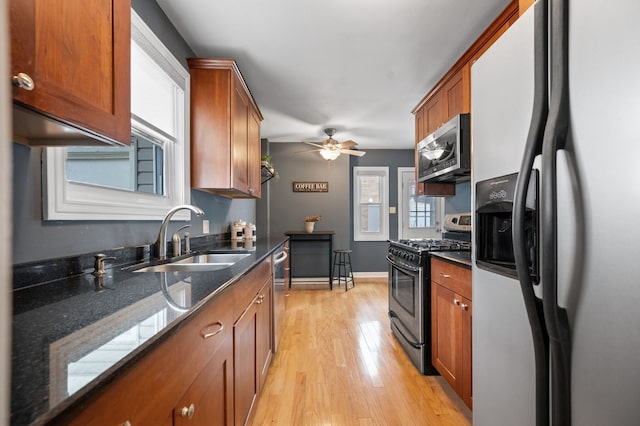 231 W Hickory Rd, Lombard, IL 60148 - kitchen featuring stainless steel appliances, brown cabinets, light wood-style floors, ceiling fan, and dark stone counters