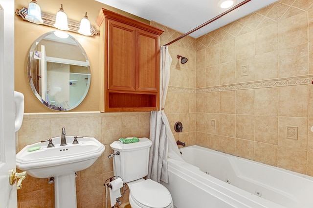 bathroom with a combined bath / shower with jetted tub, toilet, and tile walls