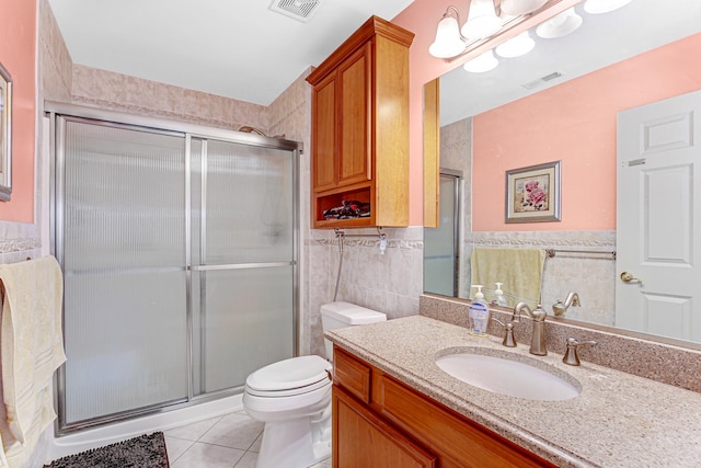 bathroom with tile walls, visible vents, a stall shower, and tile patterned flooring