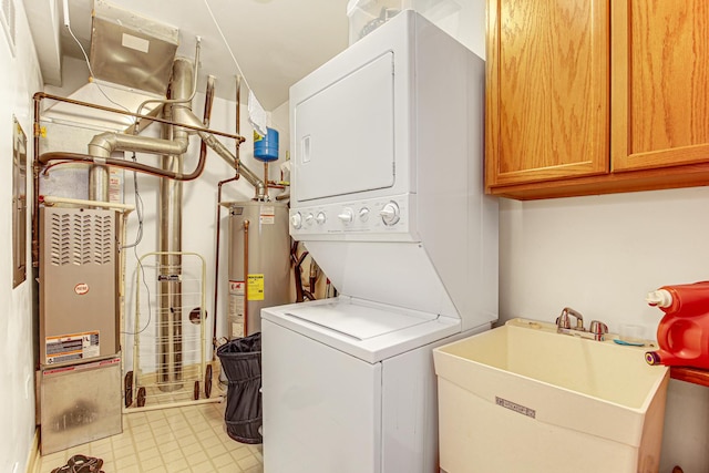 laundry room with stacked washer and clothes dryer, cabinet space, a sink, and water heater