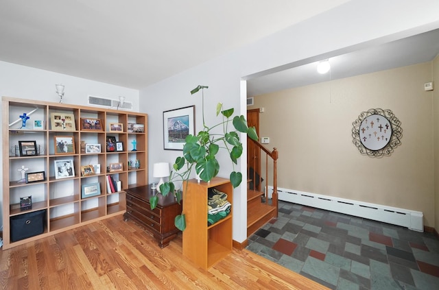 interior space featuring a baseboard heating unit and stairs