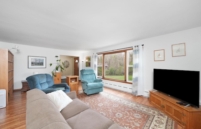 living room featuring a baseboard heating unit and light wood finished floors