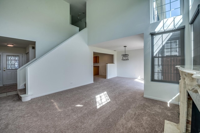 3924 Garnette Ct, Naperville, IL 60564 - unfurnished living room featuring a high ceiling, carpet flooring, baseboards, and stairs