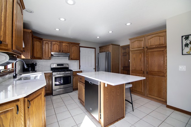 909 Revere St, Bourbonnais, IL 60914 - kitchen with a sink, a kitchen island, a breakfast bar, appliances with stainless steel finishes, and under cabinet range hood