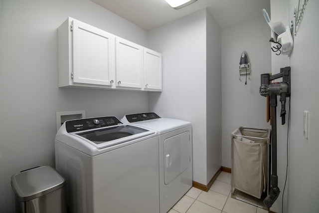 909 Revere St, Bourbonnais, IL 60914 - laundry area featuring light tile patterned flooring, baseboards, washing machine and clothes dryer, and cabinet space