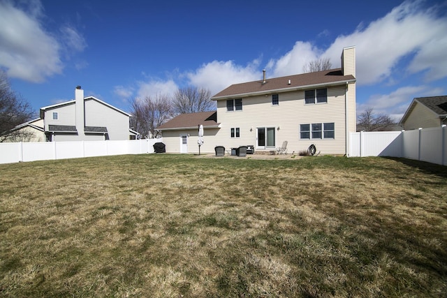 909 Revere St, Bourbonnais, IL 60914 - rear view of house with a fenced backyard, a chimney, a patio area, and a yard