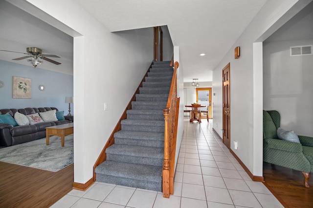 909 Revere St, Bourbonnais, IL 60914 - stairway with tile patterned floors, visible vents, baseboards, and a ceiling fan