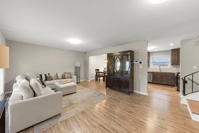 living room with baseboards and light wood-style flooring