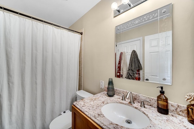 bathroom with curtained shower, vanity, and toilet