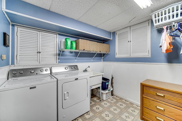 washroom with washer and dryer, laundry area, wainscoting, and light floors
