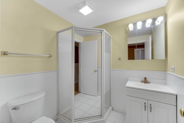 full bath featuring a shower stall, vanity, tile patterned flooring, and toilet