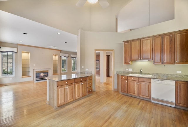4517 S Seminole Dr, Glenview, IL 60026 - kitchen featuring a glass covered fireplace, light wood-style floors, white dishwasher, open floor plan, and a sink