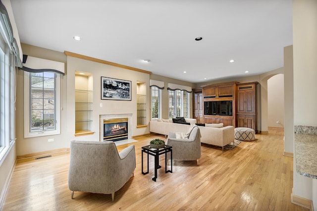 4517 S Seminole Dr, Glenview, IL 60026 - living area featuring a fireplace, arched walkways, baseboards, light wood-type flooring, and visible vents