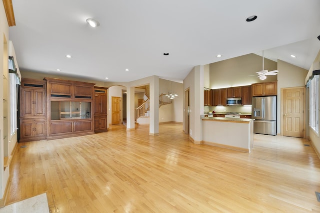 4517 S Seminole Dr, Glenview, IL 60026 - kitchen featuring arched walkways, stainless steel appliances, a peninsula, and light wood-style flooring