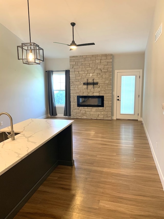 1805 Glenbridge Rd, Bloomington, IL 61704 - kitchen featuring wood finished floors, a ceiling fan, visible vents, and a fireplace