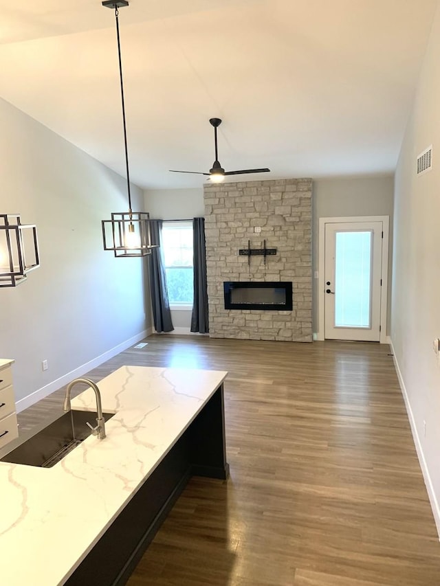 1805 Glenbridge Rd, Bloomington, IL 61704 - living area with baseboards, visible vents, wood finished floors, ceiling fan, and a fireplace