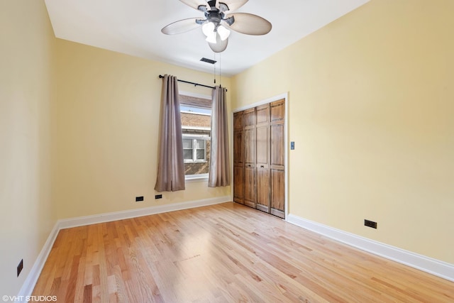 unfurnished bedroom with a closet, visible vents, baseboards, ceiling fan, and light wood-type flooring