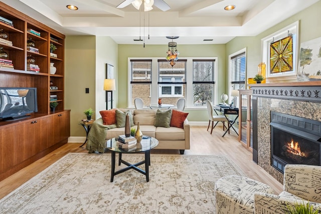 living room with a premium fireplace, baseboards, ceiling fan, wood finished floors, and recessed lighting