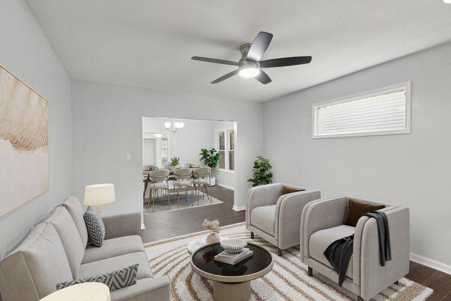living area with dark wood-style floors, ceiling fan, and baseboards
