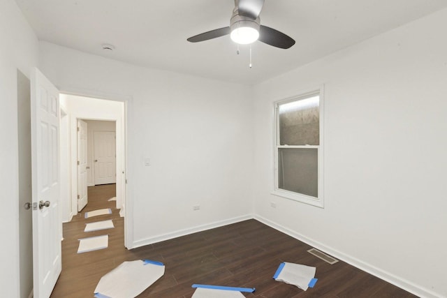 unfurnished room with a ceiling fan, dark wood-type flooring, baseboards, and visible vents