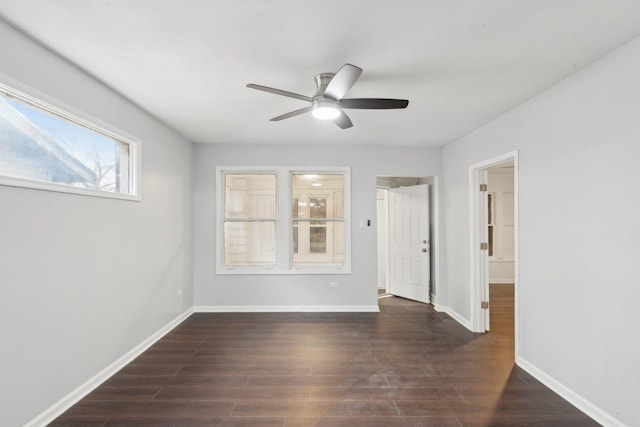 empty room with a ceiling fan, baseboards, and wood finished floors