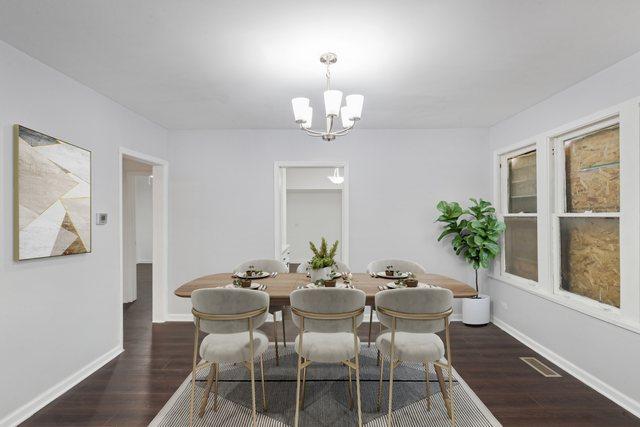 dining room with visible vents, baseboards, a chandelier, and wood finished floors