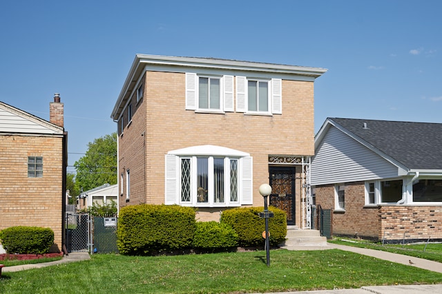 9724 S Princeton Ave, Chicago, IL 60628 - traditional-style house with brick siding, a front yard, and a gate
