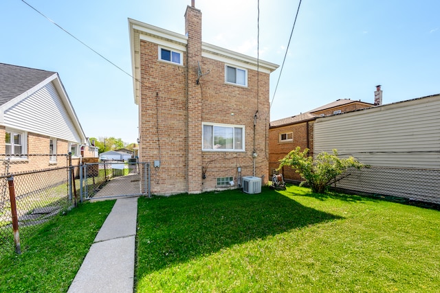 9724 S Princeton Ave, Chicago, IL 60628 - rear view of property featuring brick siding, a gate, a chimney, and central AC unit