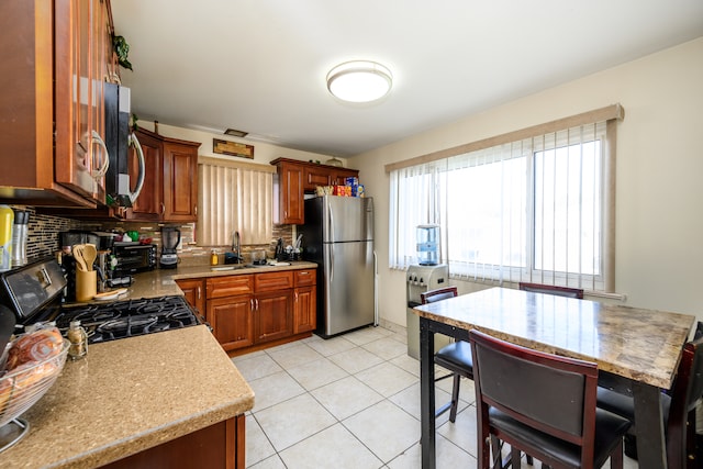 9724 S Princeton Ave, Chicago, IL 60628 - kitchen with stainless steel appliances, a sink, backsplash, light countertops, and light tile patterned floors