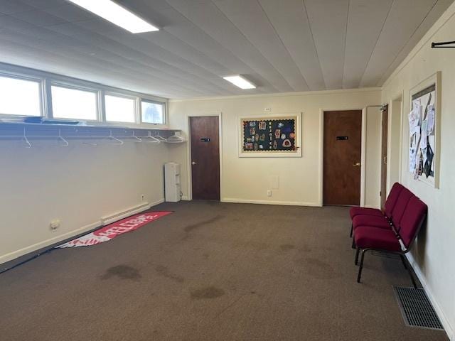 below grade area with baseboards, visible vents, and carpet flooring