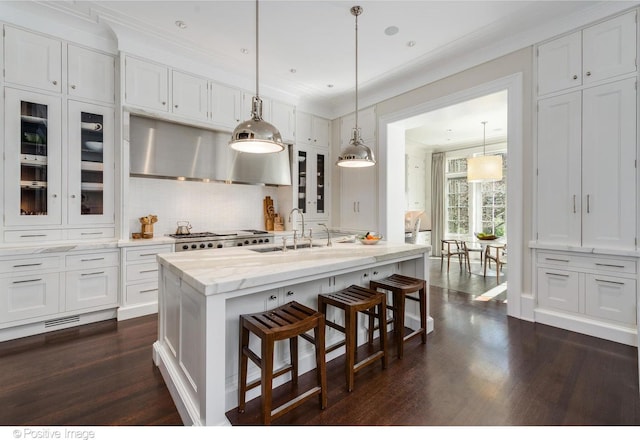 1853 N Burling St, Chicago, IL 60614 - kitchen with crown molding, white cabinets, a kitchen breakfast bar, dark wood-type flooring, and glass insert cabinets