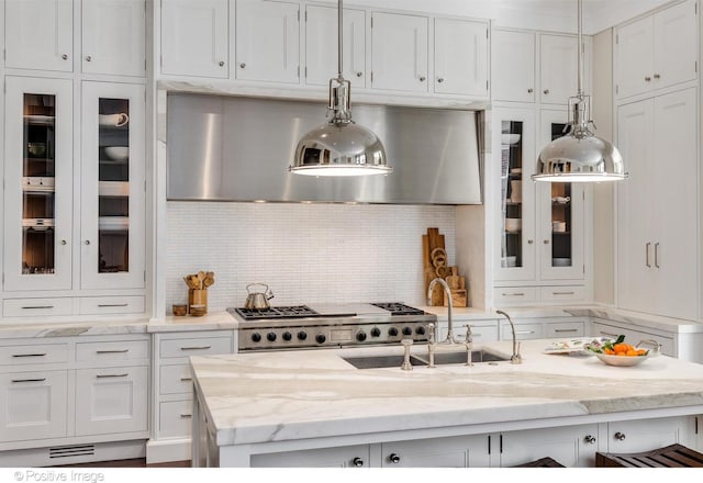 1853 N Burling St, Chicago, IL 60614 - kitchen featuring white cabinets, a sink, decorative backsplash, glass insert cabinets, and light stone counters