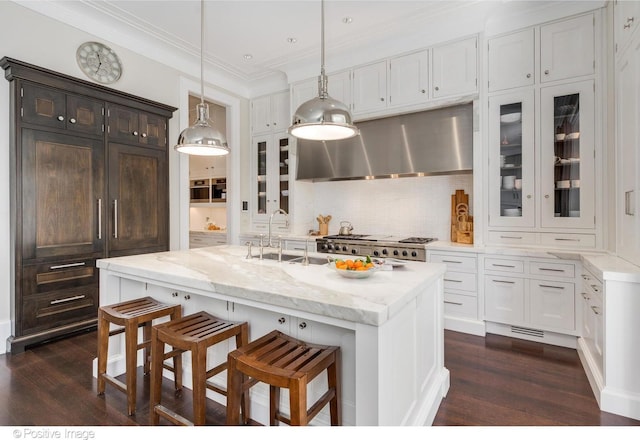1853 N Burling St, Chicago, IL 60614 - kitchen with a sink, wall chimney range hood, ornamental molding, dark wood finished floors, and a breakfast bar area