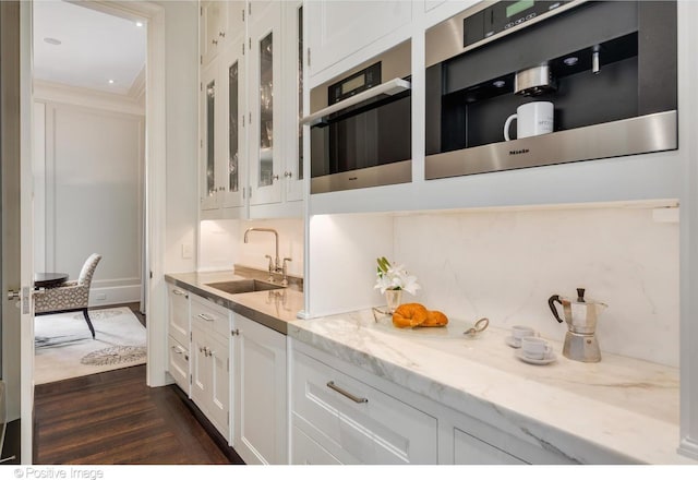 1853 N Burling St, Chicago, IL 60614 - kitchen featuring a sink, dark wood finished floors, glass insert cabinets, white cabinetry, and light stone countertops