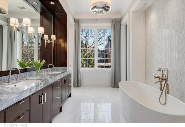 1853 N Burling St, Chicago, IL 60614 - full bathroom with a freestanding bath, double vanity, wallpapered walls, ornamental molding, and baseboards