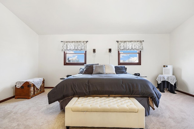 bedroom with baseboards and light colored carpet