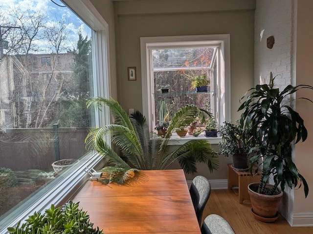 dining space with baseboards and wood finished floors