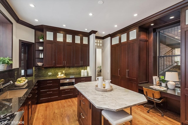 kitchen with a sink, ornamental molding, light wood-style floors, and open shelves