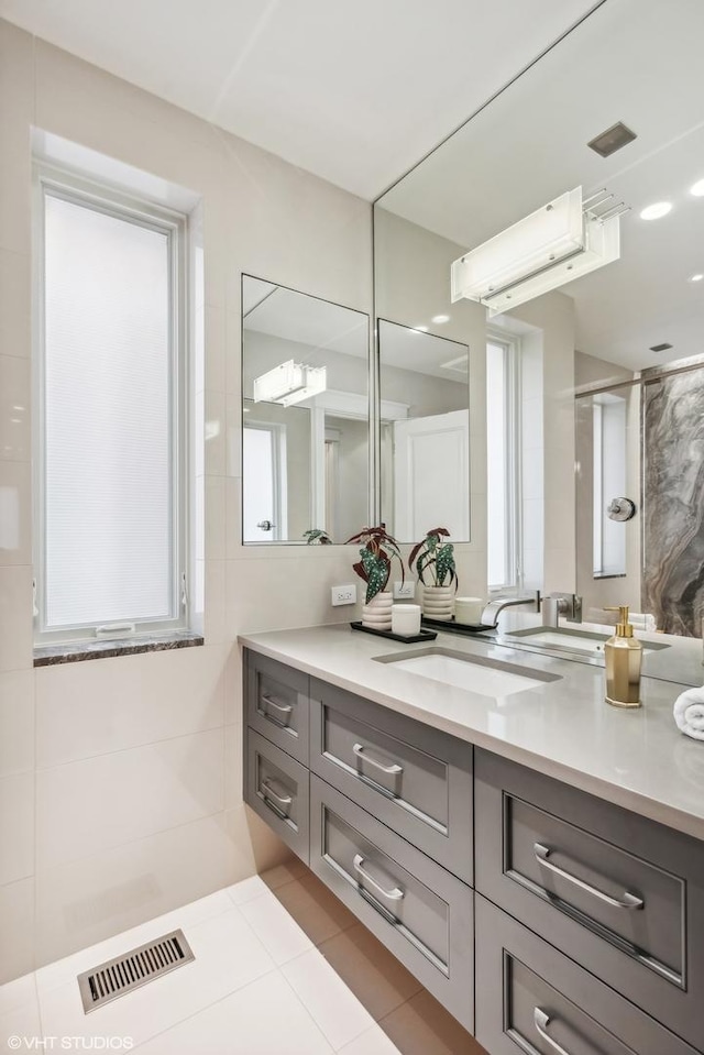 bathroom with vanity, a wealth of natural light, tile walls, and visible vents