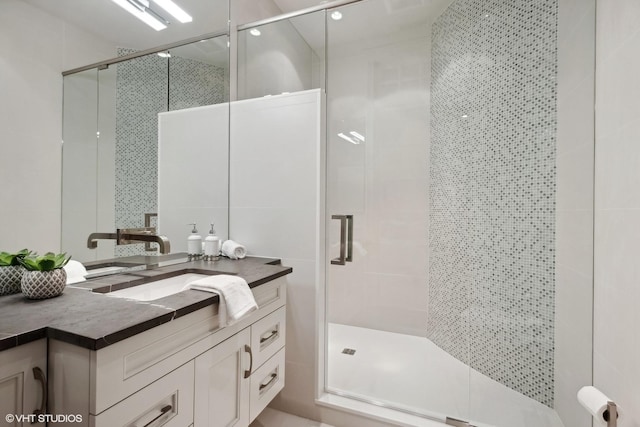 bathroom with tile walls, a stall shower, and vanity