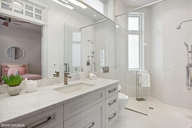 bathroom featuring a shower stall, a wealth of natural light, toilet, and vanity