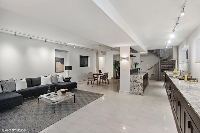living area featuring track lighting and stairs