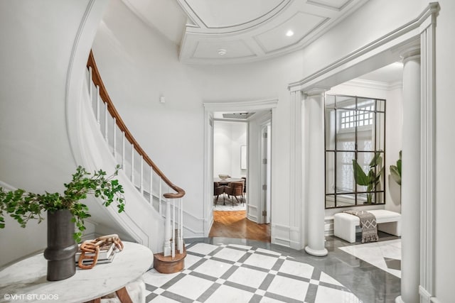 foyer featuring crown molding, ornate columns, stairway, recessed lighting, and coffered ceiling