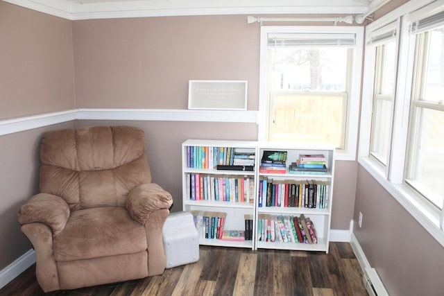 living area featuring baseboards, wood finished floors, and ornamental molding
