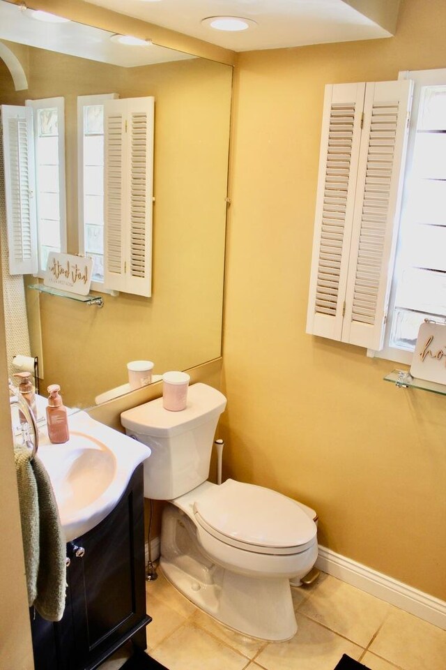 bathroom featuring baseboards, toilet, tile patterned flooring, and vanity